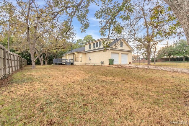 view of side of home with a lawn and a wooden deck