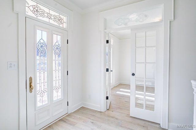 foyer with french doors, crown molding, and light hardwood / wood-style flooring