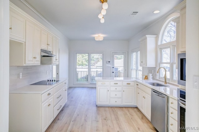 kitchen with sink, stainless steel appliances, kitchen peninsula, and white cabinets