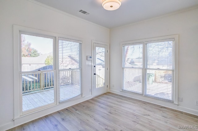 doorway to outside featuring ornamental molding and light hardwood / wood-style floors