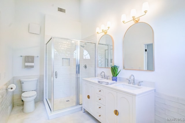 bathroom featuring a shower with door, vanity, tile patterned floors, and toilet