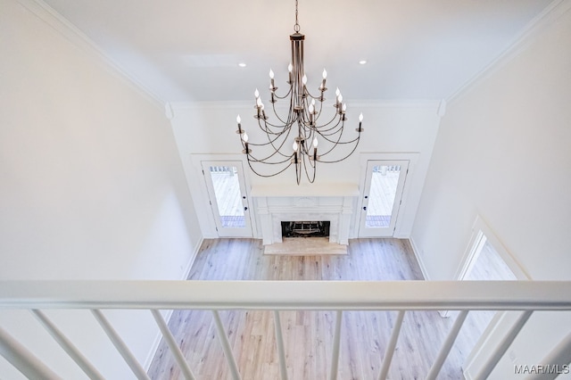 unfurnished living room with ornamental molding, light wood-type flooring, and a fireplace