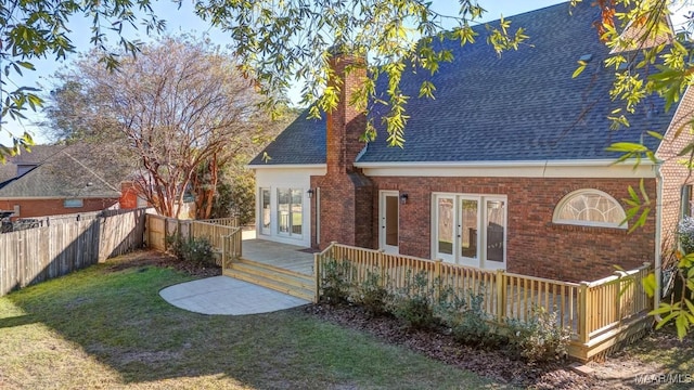 exterior space featuring a wooden deck and a lawn