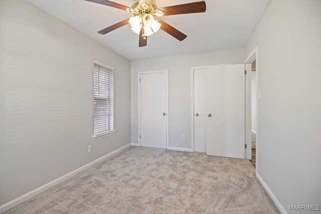 unfurnished bedroom with ceiling fan and light colored carpet