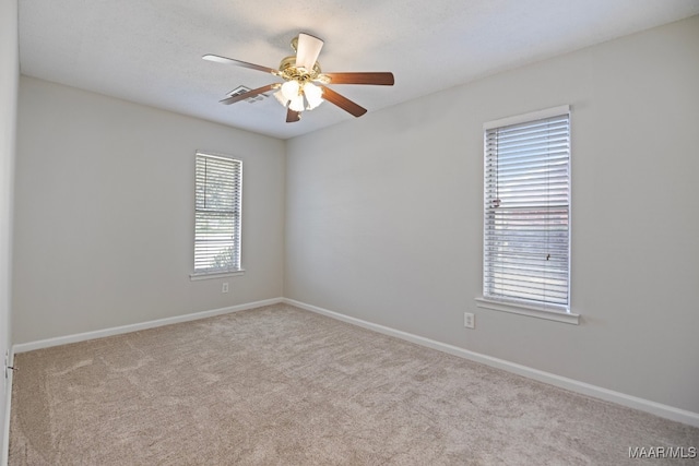 carpeted empty room featuring plenty of natural light and ceiling fan