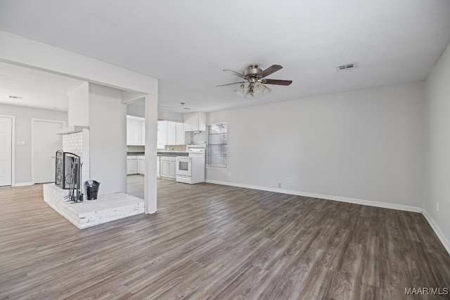 unfurnished living room with hardwood / wood-style floors, ceiling fan, and a fireplace