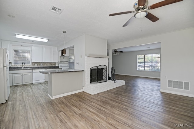 kitchen with sink, light hardwood / wood-style flooring, pendant lighting, white appliances, and white cabinets