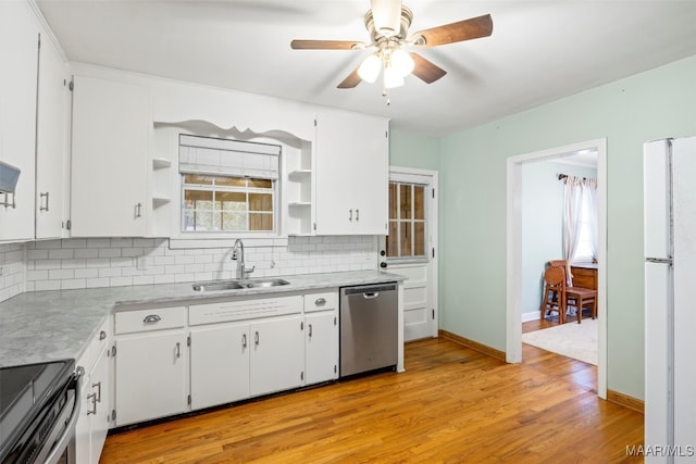 kitchen with backsplash, stainless steel appliances, sink, white cabinets, and light hardwood / wood-style floors