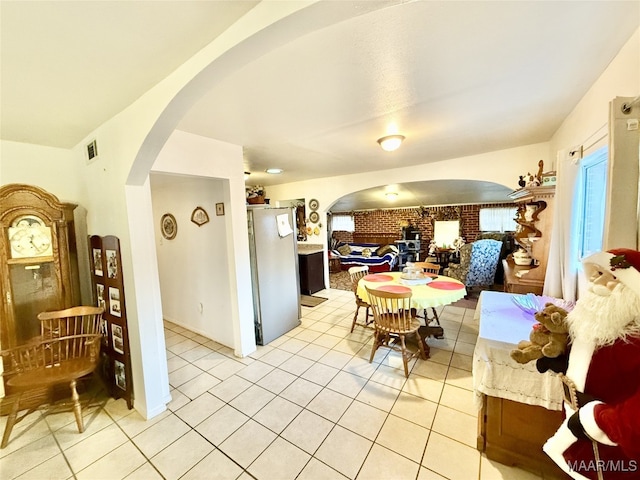 tiled dining area featuring brick wall