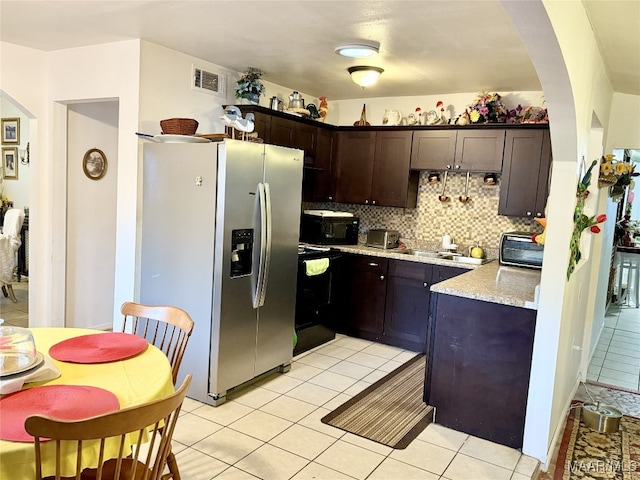 kitchen with backsplash, black appliances, sink, dark brown cabinets, and light tile patterned flooring