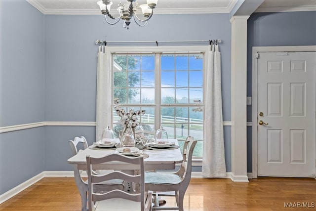 dining room featuring ornamental molding, wood-type flooring, and an inviting chandelier