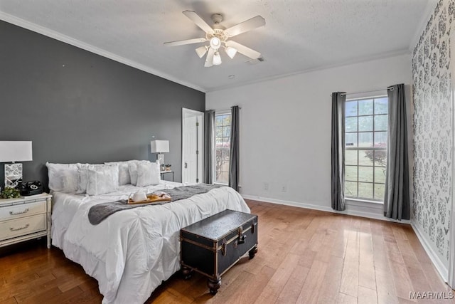 bedroom featuring hardwood / wood-style flooring, ceiling fan, and crown molding