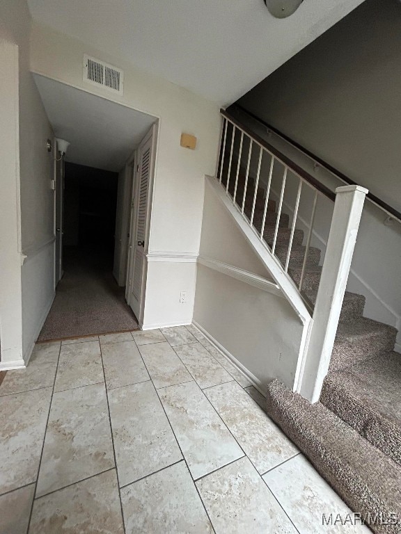 stairs featuring tile patterned flooring