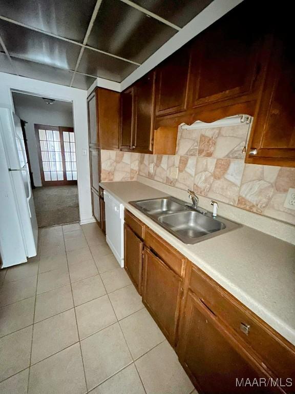 524 Winston Dr Unit 2D, Montgomery, AL 36111 - kitchen with a sink, freestanding refrigerator, light tile patterned floors, decorative backsplash, and light countertops