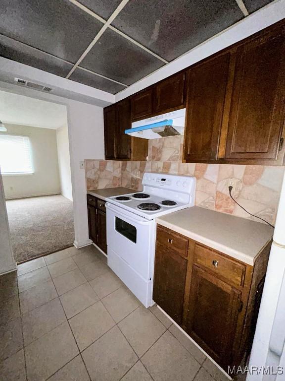 524 Winston Dr Unit 2D, Montgomery, AL 36111 - kitchen with under cabinet range hood, white electric range, light carpet, decorative backsplash, and light countertops