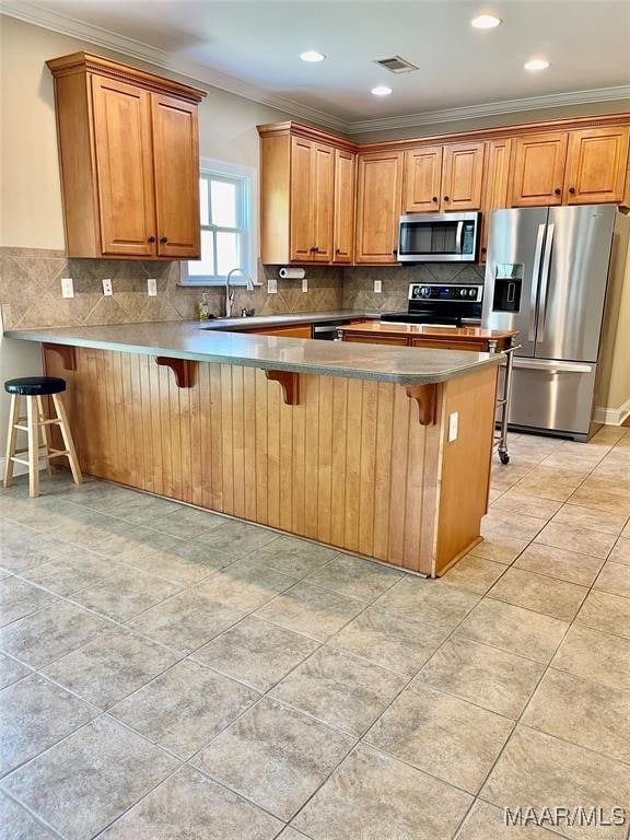 kitchen with a kitchen breakfast bar, kitchen peninsula, and appliances with stainless steel finishes