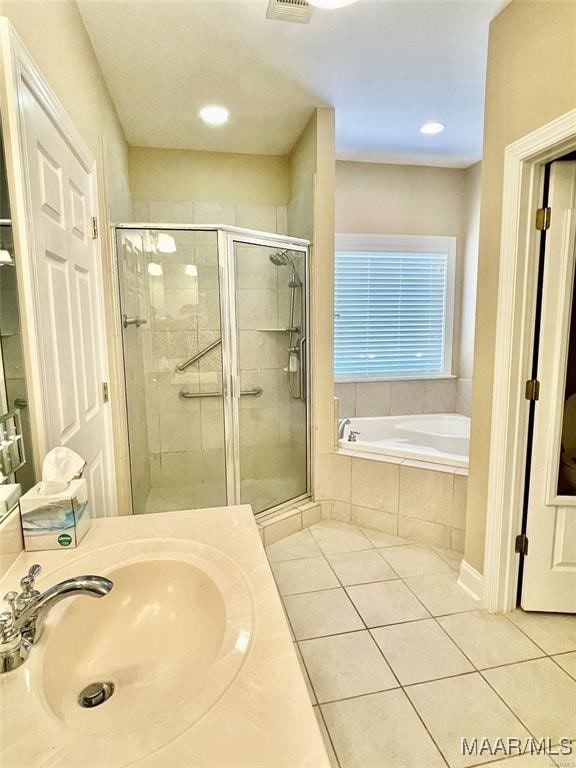 bathroom featuring plus walk in shower, vanity, and tile patterned floors