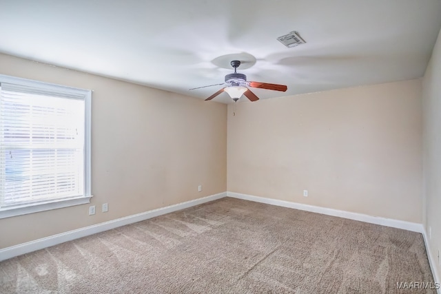 carpeted empty room with ceiling fan and a healthy amount of sunlight