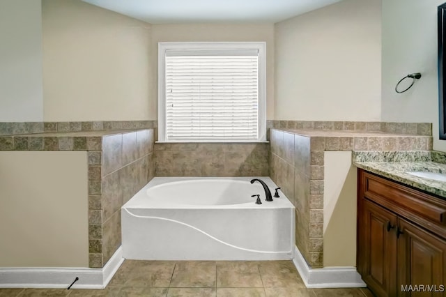 bathroom featuring tile patterned floors, vanity, a bath, and tile walls