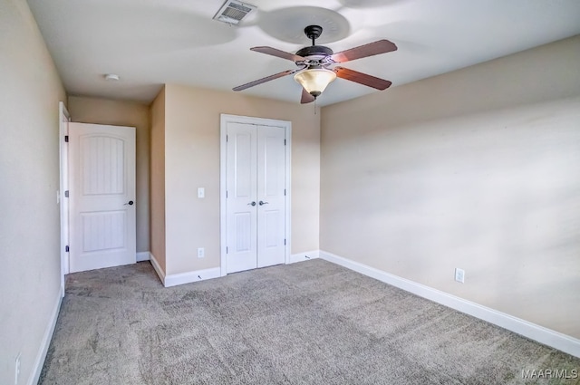 unfurnished bedroom featuring ceiling fan, a closet, and light colored carpet