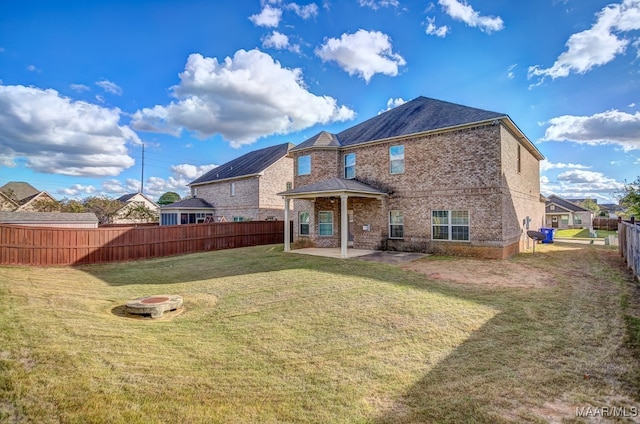 rear view of house featuring a lawn and a patio