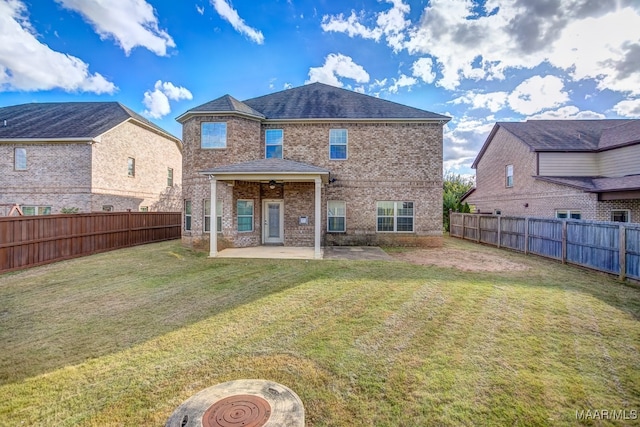 back of property with a yard, a patio, and ceiling fan