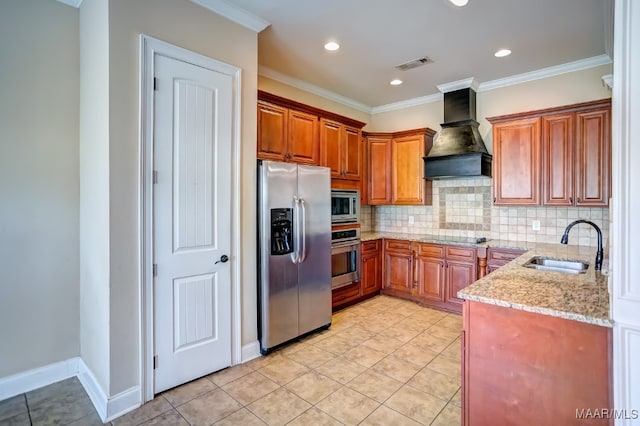 kitchen with sink, light stone countertops, appliances with stainless steel finishes, light tile patterned flooring, and custom range hood