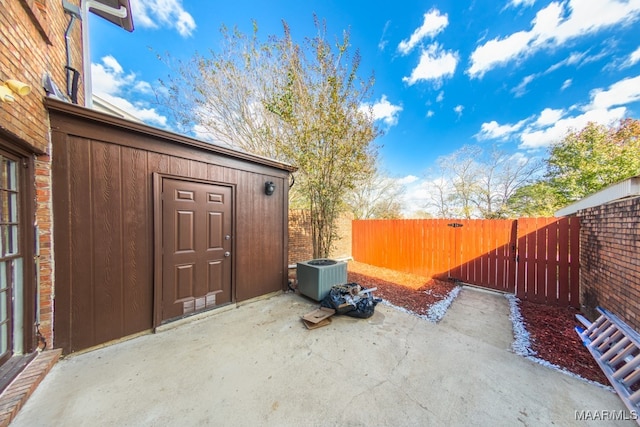 view of patio / terrace with cooling unit and a shed