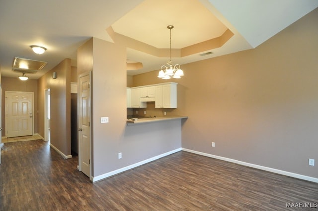 kitchen featuring white cabinets, dark hardwood / wood-style floors, kitchen peninsula, and hanging light fixtures