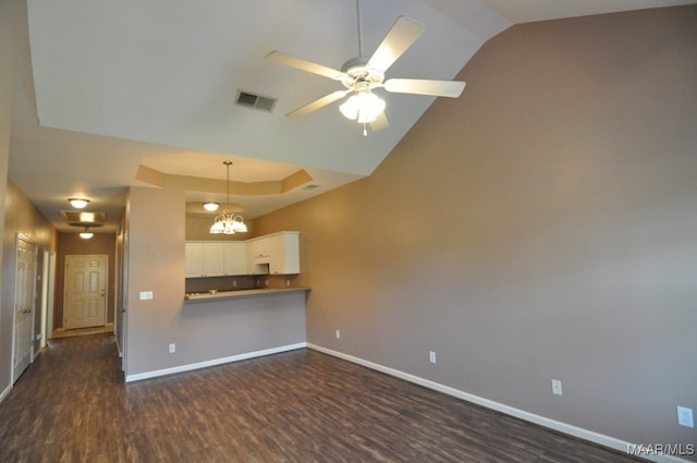 unfurnished living room featuring ceiling fan with notable chandelier and dark hardwood / wood-style floors