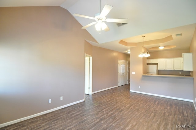 unfurnished living room with ceiling fan with notable chandelier, dark hardwood / wood-style flooring, and lofted ceiling