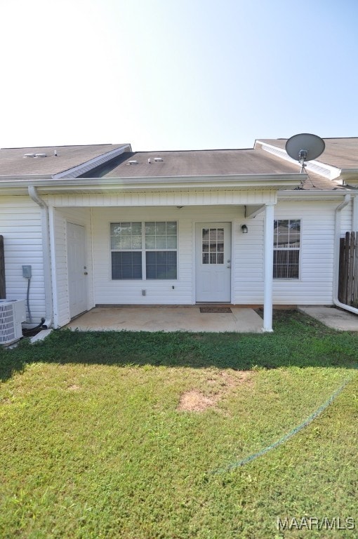 rear view of property with a yard, a patio, and central AC unit