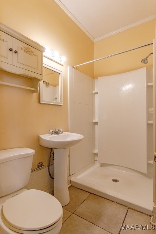 bathroom featuring a shower, tile patterned floors, sink, toilet, and ornamental molding