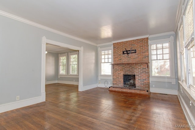 unfurnished living room with hardwood / wood-style floors, ornamental molding, and a brick fireplace