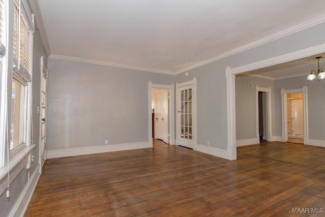 empty room featuring a chandelier, dark hardwood / wood-style flooring, and crown molding