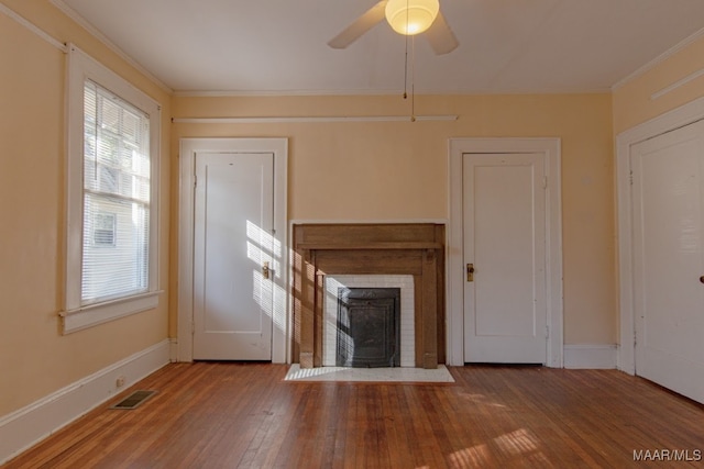 unfurnished living room featuring hardwood / wood-style floors, ceiling fan, and ornamental molding