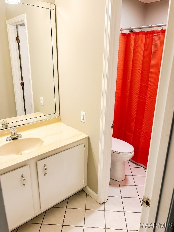 bathroom with tile patterned flooring, vanity, and toilet