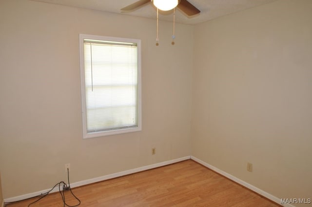 empty room with ceiling fan and light hardwood / wood-style flooring