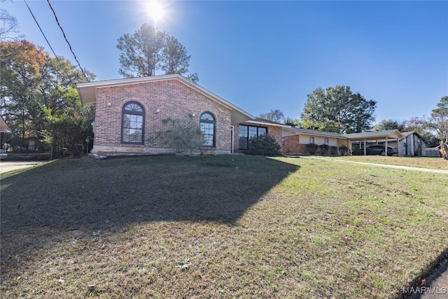 ranch-style home with a carport and a front lawn