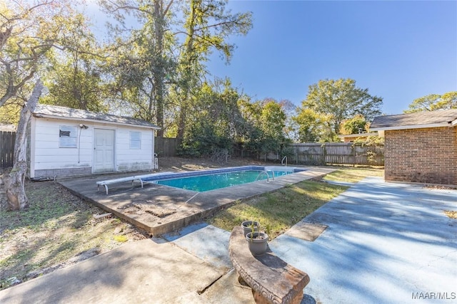 view of swimming pool featuring a patio area, a diving board, and an outbuilding