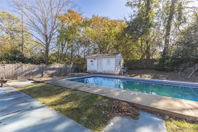 view of swimming pool featuring an outbuilding and a diving board