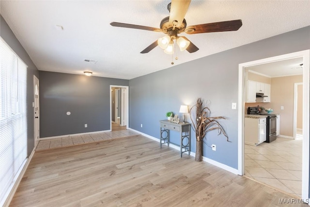 spare room with a textured ceiling, light hardwood / wood-style floors, and ceiling fan