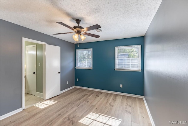 unfurnished bedroom featuring ceiling fan, light hardwood / wood-style floors, and a textured ceiling