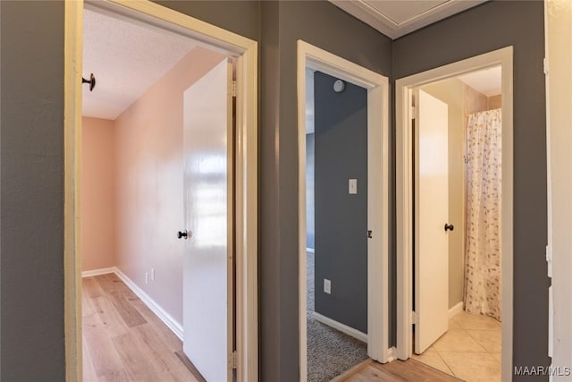 hall featuring a textured ceiling and light hardwood / wood-style flooring