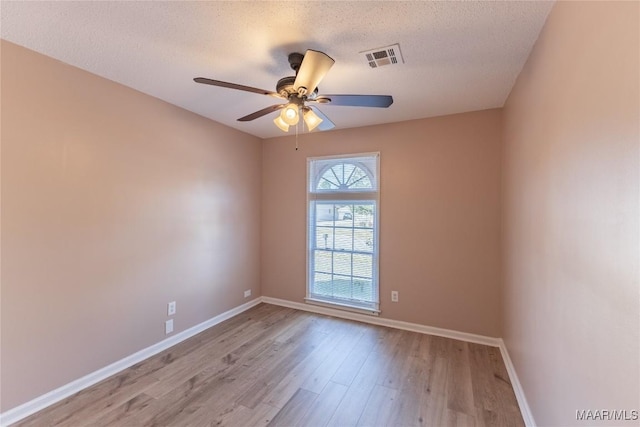 unfurnished room with ceiling fan, light hardwood / wood-style flooring, and a textured ceiling