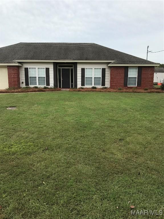 single story home featuring a front lawn