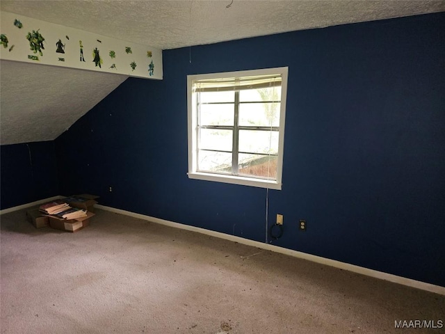 unfurnished room featuring carpet, a textured ceiling, and lofted ceiling