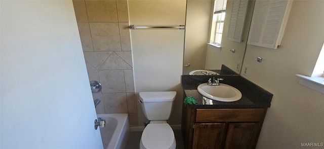 bathroom with a washtub, vanity, and toilet