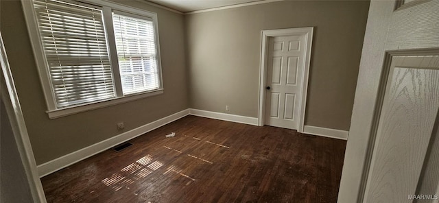 spare room with crown molding and dark wood-type flooring