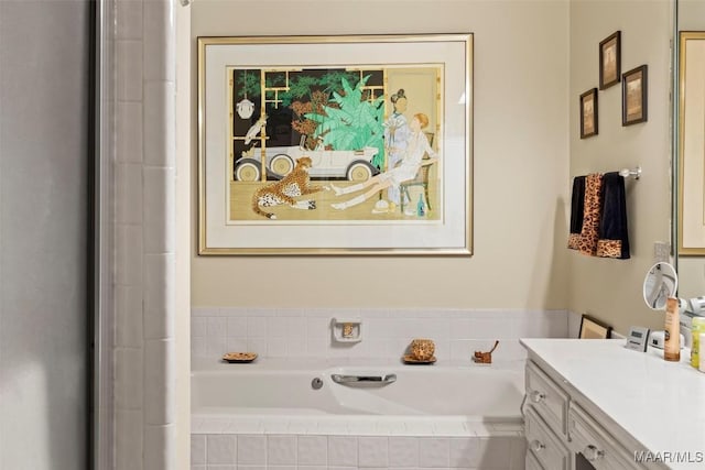 bathroom with vanity and tiled bath